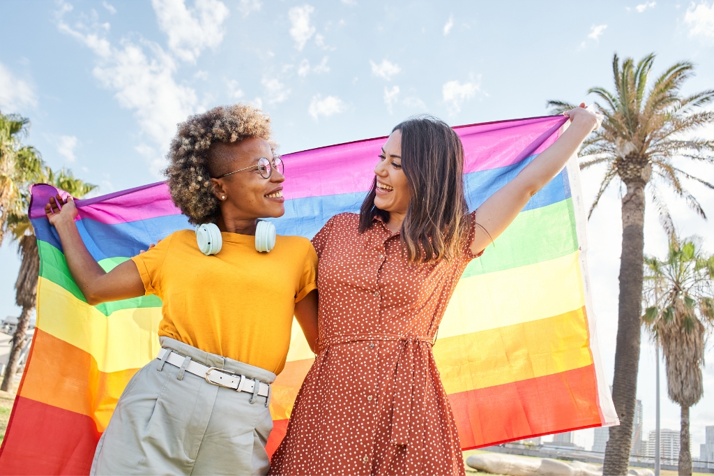Couple of girls with LGBTQ+ rainbow flag